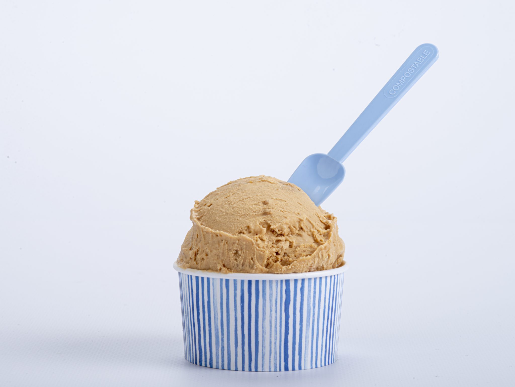 Cucharita compostable azul en helado de chocolate